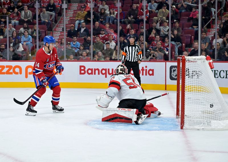 Sep 24, 2024; Montreal, Quebec, CAN; Montreal Canadiens forward Nick Suzuki (14) scores a goal against New Jersey Devils goalie Nico Daws (50) during the third period at the Bell Centre. Mandatory Credit: Eric Bolte-Imagn Images