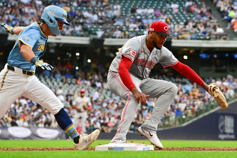 Jun 14, 2024; Milwaukee, Wisconsin, USA; Cincinnati Reds starting pitcher Hunter Greene (21) steps on first base before Milwaukee Brewers  right fielder Sal Frelick (10) for the out in the second inning at American Family Field. Mandatory Credit: Benny Sieu-USA TODAY Sports