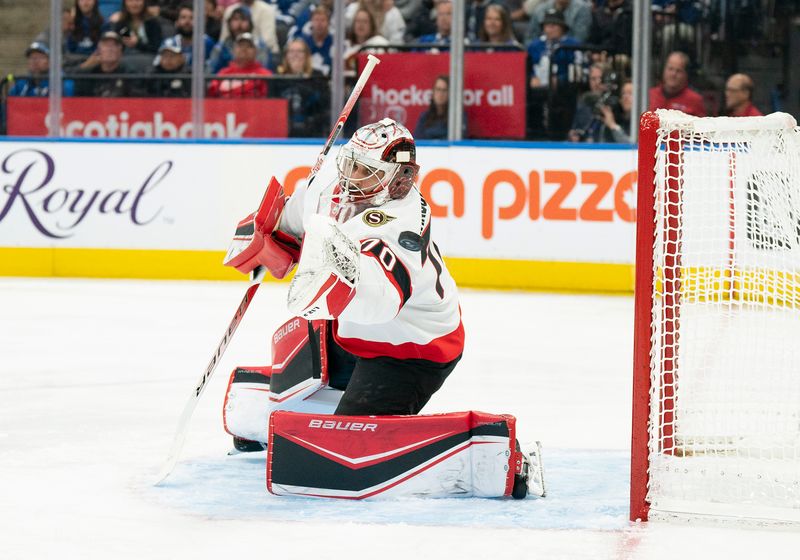 Sep 24, 2022; Toronto, Ontario, CAN; Ottawa Senators goaltender Kevin Mandolese (70) tries to stop a puck against the Toronto Maple Leafs during the third period at Scotiabank Arena. Mandatory Credit: Nick Turchiaro-USA TODAY Sports