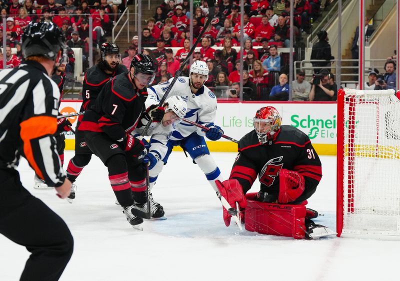 Oct 11, 2024; Raleigh, North Carolina, USA;  Carolina Hurricanes goaltender Frederik Andersen (31) and defenseman Dmitry Orlov (7) clear the puck away from Tampa Bay Lightning left wing Brandon Hagel (38) and center Anthony Cirelli (71) during the second period at PNC Arena. Mandatory Credit: James Guillory-Imagn Images