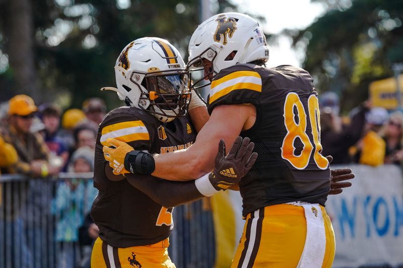 Sep 10, 2022; Laramie, Wyoming, USA; Wyoming Cowboys running back Titus Swen (2) celebrates after a touchdown with teammate Parker Christensen (80) against the Northern Colorado Bears during the fourth quarter at Jonah Field at War Memorial Stadium. Mandatory Credit: Troy Babbitt-USA TODAY Sports