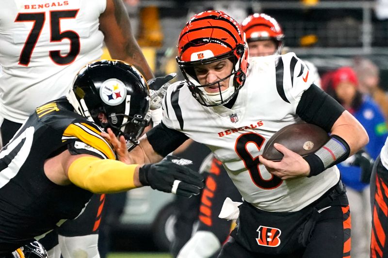 Cincinnati Bengals quarterback Jake Browning, right, is sacked by Pittsburgh Steelers linebacker T.J. Watt (90) during the first half of an NFL football game in Pittsburgh, Saturday, Dec. 23, 2023. (AP Photo/Gene J. Puskar)