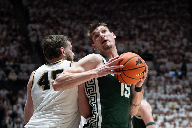 Feb 26, 2026; West Lafayette, Indiana, USA; Michigan State Spartans center Carson Cooper (15) dribbles around Purdue Boilermakers center Oscar Cluff (45) during the first half at Mackey Arena. Mandatory Credit: Jacob Musselman-Imagn Images