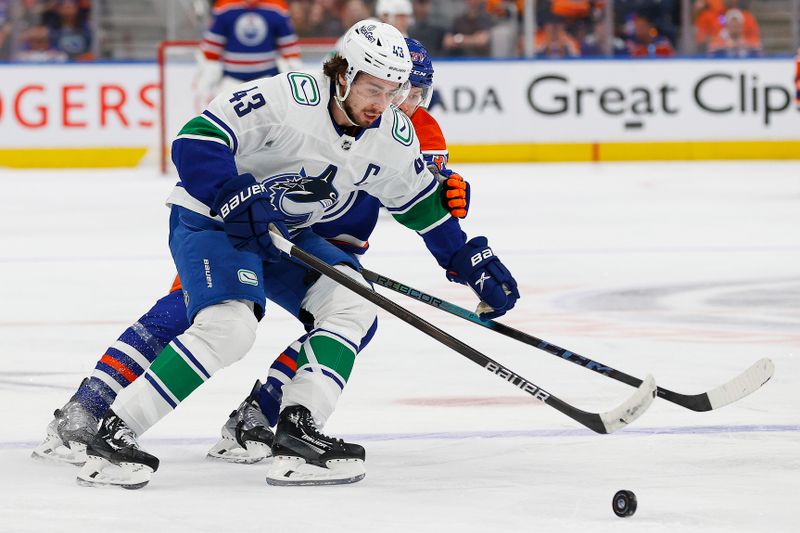 May 12, 2024; Edmonton, Alberta, CAN;Vancouver Canucks defensemen Quinn Hughes (43) protects the puck from Edmonton Oilers forward Warren Foegele (37) during the first period in game three of the second round of the 2024 Stanley Cup Playoffs at Rogers Place. Mandatory Credit: Perry Nelson-USA TODAY Sports