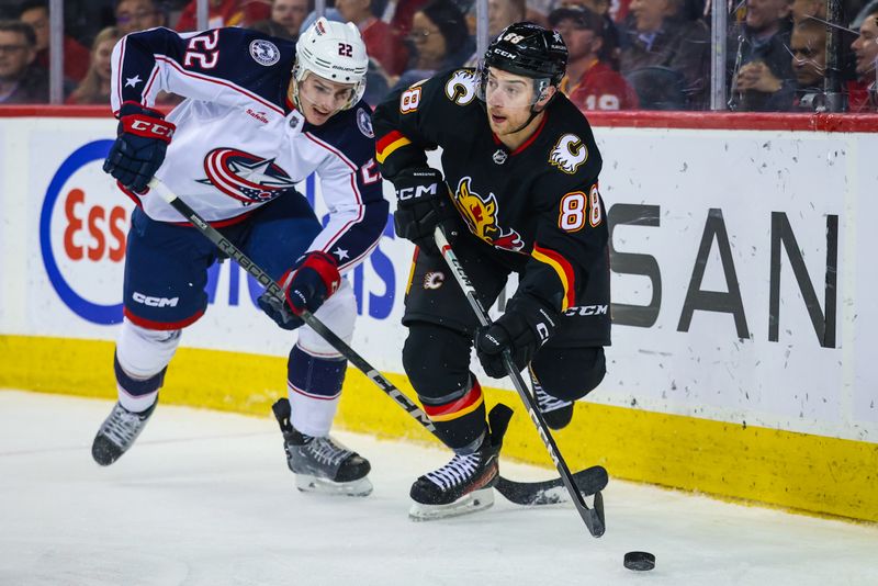Jan 25, 2024; Calgary, Alberta, CAN; Calgary Flames left wing Andrew Mangiapane (88) and Columbus Blue Jackets defenseman Jake Bean (22) battles for the puck during the third period at Scotiabank Saddledome. Mandatory Credit: Sergei Belski-USA TODAY Sports