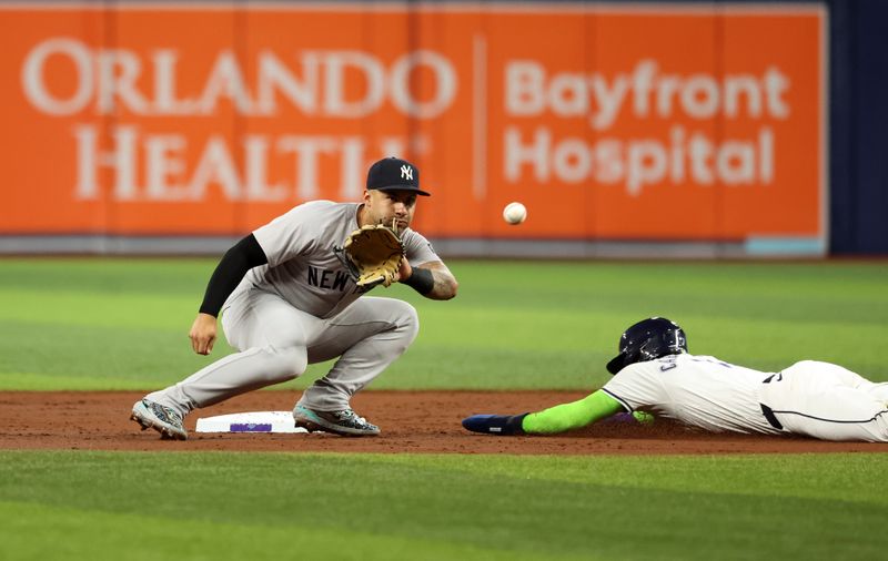 May 10, 2024; St. Petersburg, Florida, USA; New York Yankees second base Gleyber Torres (25) attempts to tag out Tampa Bay Rays shortstop José Caballero (7) as he slides safe into second base during the third inning at Tropicana Field. Mandatory Credit: Kim Klement Neitzel-USA TODAY Sports