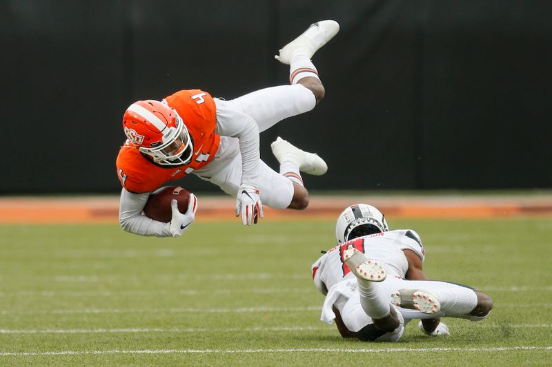 Nov 28, 2020; Oklahoma State Cowboys wide receiver Tay Martin (4) is brought down by Texas Tech Red Raiders defensive back Zech McPhearson (8) during a football game at Boone Pickens Stadium. Mandatory Credit: Bryan Terry-USA TODAY Sports