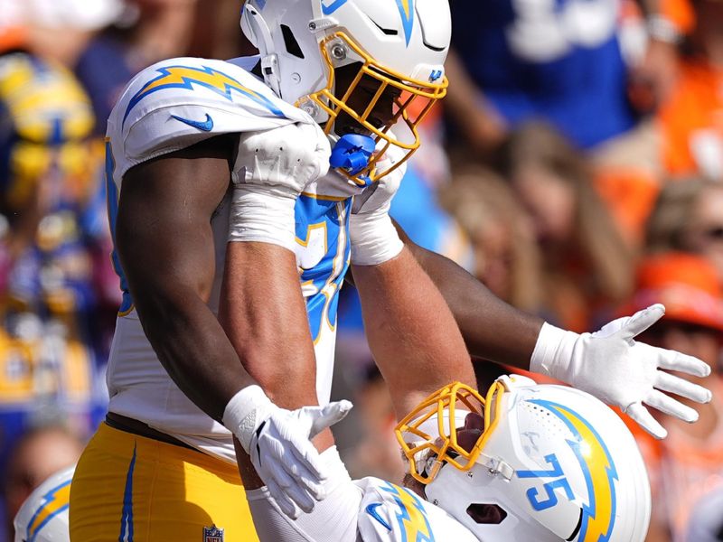 Los Angeles Chargers running back Kimani Vidal (30) celebrates with center Bradley Bozeman (75) after scoring a 38-yard touchdown during the first half of an NFL football game against the Denver Broncos, Sunday, Oct. 13, 2024, in Denver. (AP Photo/David Zalubowski)