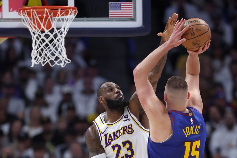 DENVER, COLORADO - APRIL 20: LeBron James #23 of the Los Angeles Lakers guards Nikola Jokic #15 of the Denver Nuggets in the first quarter during game one of the Western Conference First Round Playoffs at Ball Arena on April 20, 2024 in Denver, Colorado.  NOTE TO USER: User expressly acknowledges and agrees that, by downloading and or using this photograph, User is consenting to the terms and conditions of the Getty Images License Agreement. (Photo by Matthew Stockman/Getty Images)