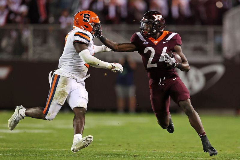 Oct 26, 2023; Blacksburg, Virginia, USA; Virginia Tech Hokies running back Malachi Thomas (24) runs the ball against Syracuse Orange linebacker Marlowe Wax (2) during the fourth quarterat Lane Stadium. Mandatory Credit: Peter Casey-USA TODAY Sports