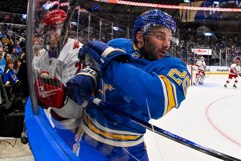 Oct 19, 2024; St. Louis, Missouri, USA;  St. Louis Blues left wing Nathan Walker (26) checks Carolina Hurricanes defenseman Sean Walker (26) during the second period at Enterprise Center. Mandatory Credit: Jeff Curry-Imagn Images