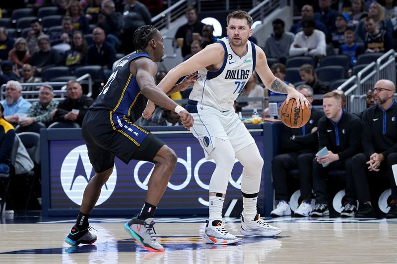 INDIANAPOLIS, INDIANA - MARCH 27: Luka Doncic #77 of the Dallas Mavericks dribbles the ball while being guarded by Aaron Nesmith #23 of the Indiana Pacers in the first quarter at Gainbridge Fieldhouse on March 27, 2023 in Indianapolis, Indiana. NOTE TO USER: User expressly acknowledges and agrees that, by downloading and or using this photograph, User is consenting to the terms and conditions of the Getty Images License Agreement. (Photo by Dylan Buell/Getty Images)