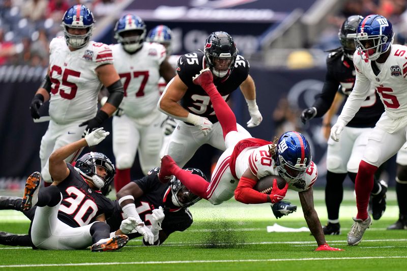 New York Giants running back Eric Gray (20) is tackled as he runs the ball by Houston Texans cornerback Myles Bryant (30) in the second half of a preseason NFL football game, Saturday, Aug. 17, 2024, in Houston. (AP Photo/Eric Gay)