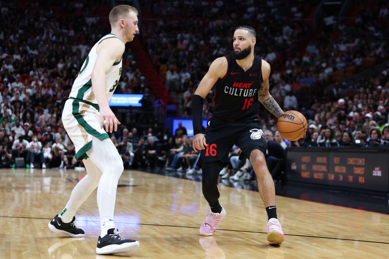 MIAMI, FLORIDA - FEBRUARY 11: Caleb Martin #16 of the Miami Heat dribbles the ball against Sam Hauser #30 of the Boston Celtics during the fourth quarter of the game at Kaseya Center on February 11, 2024 in Miami, Florida. NOTE TO USER: User expressly acknowledges and agrees that, by downloading and or using this photograph, User is consenting to the terms and conditions of the Getty Images License Agreement. (Photo by Megan Briggs/Getty Images)