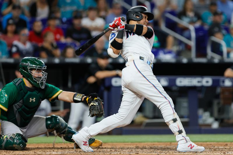 Jun 4, 2023; Miami, Florida, USA; Miami Marlins second baseman Luis Arraez (3) hits an RBI single against the Oakland Athletics during the eighth inning at loanDepot Park. Mandatory Credit: Sam Navarro-USA TODAY Sports