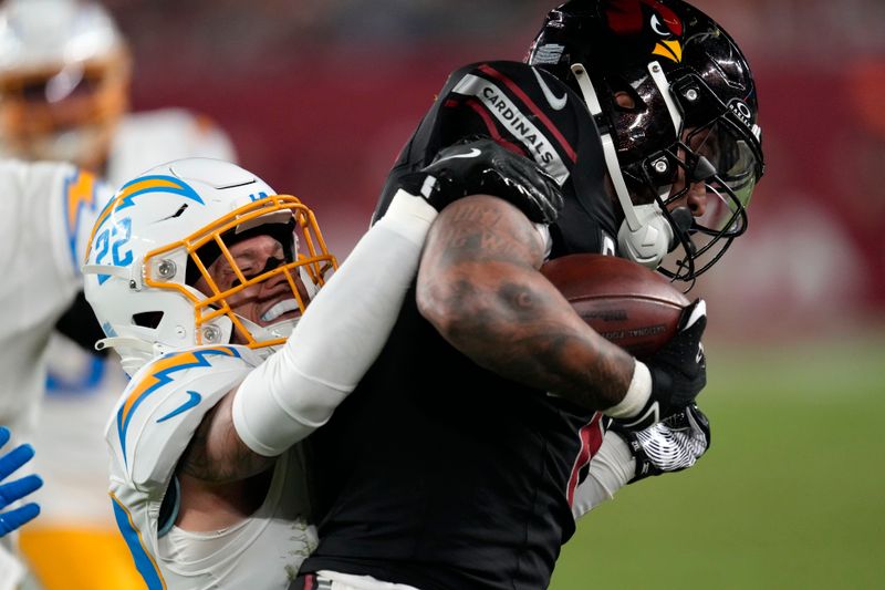 Arizona Cardinals running back James Conner is tackled by Los Angeles Chargers cornerback Elijah Molden, left, during the second half of an NFL football game, Monday, Oct. 21, 2024, in Glendale Ariz. (AP Photo/Matt York)