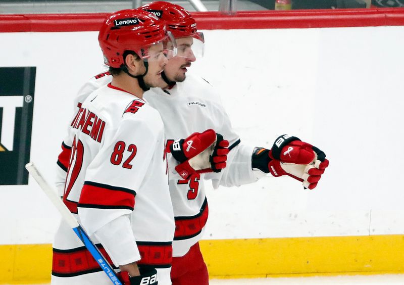 Mar 26, 2024; Pittsburgh, Pennsylvania, USA; Carolina Hurricanes center Jesperi Kotkaniemi (82) and defenseman Dmitry Orlov (right) celebrate a goal by Orlov against the Pittsburgh Penguins during the second period at PPG Paints Arena. Mandatory Credit: Charles LeClaire-USA TODAY Sports