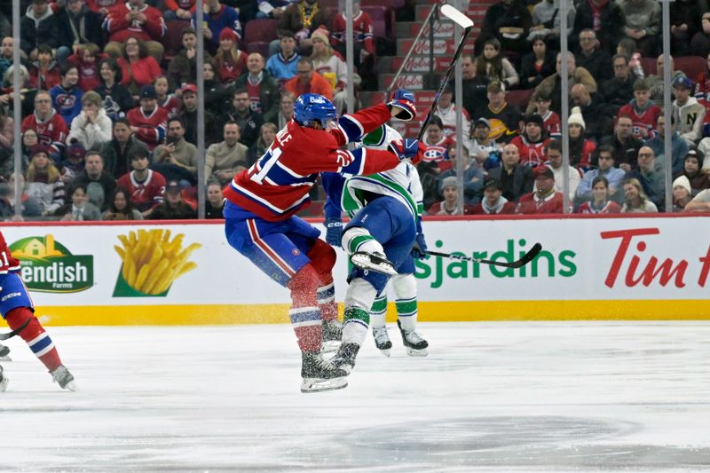 Jan 6, 2025; Montreal, Quebec, CAN; Montreal Canadiens defenseman Kaiden Guhle (21) checks Vancouver Canucks forward Jonathan Lekkerimaki (23) during the first period at the Bell Centre. Mandatory Credit: Eric Bolte-Imagn Images