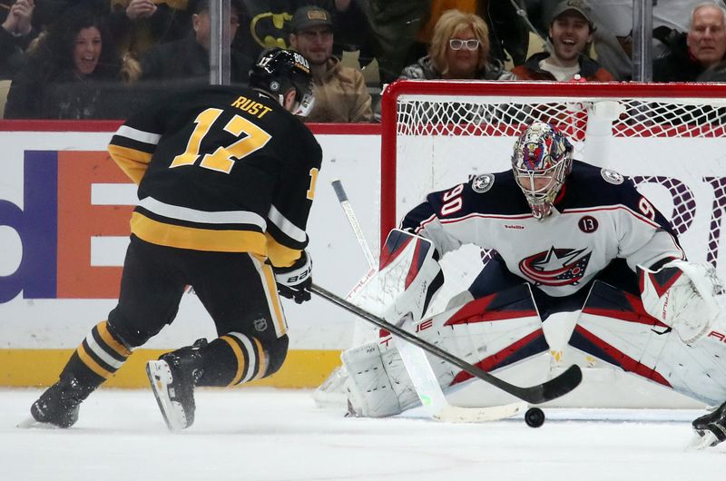 Jan 7, 2025; Pittsburgh, Pennsylvania, USA; Columbus Blue Jackets goaltender Elvis Merzlikins (90) defends the net against Pittsburgh Penguins right wing Bryan Rust (17) in overtime at PPG Paints Arena. Mandatory Credit: Charles LeClaire-Imagn Images