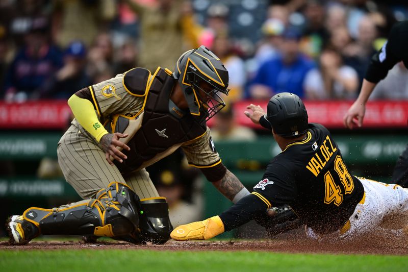 May 3, 2025; Pittsburgh, Pennsylvania, USA; Pittsburgh Pirates first baseman Enmanuel Valdez (48) is tagged out by San Diego Padres catcher Martin Maldonado (15) while attempting to score during the third inning at PNC Park. Mandatory Credit: David Dermer-Imagn Images