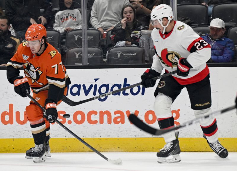 Dec 1, 2024; Anaheim, California, USA;  Anaheim Ducks right wing Frank Vatrano (77) vies for the puck with Ottawa Senators defenseman Travis Hamonic (23) during the second period at Honda Center. Mandatory Credit: Alex Gallardo-Imagn Images