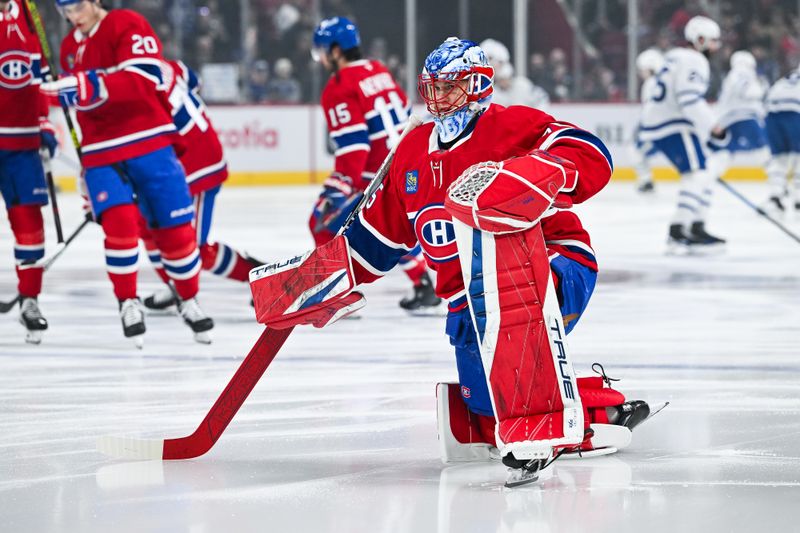 Jan 18, 2025; Montreal, Quebec, CAN; Montreal Canadiens goalie Jakub Dobes (75) stretches on the ice during warm-up before the game against the Toronto Maple Leafs at Bell Centre. Mandatory Credit: David Kirouac-Imagn Images