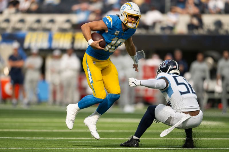 Los Angeles Chargers quarterback Justin Herbert (10) runs with the ball past Tennessee Titans linebacker Kenneth Murray Jr. (56) during an NFL football game, Sunday, Nov. 10, 2024, in Inglewood, Calif. (AP Photo/Kyusung Gong)