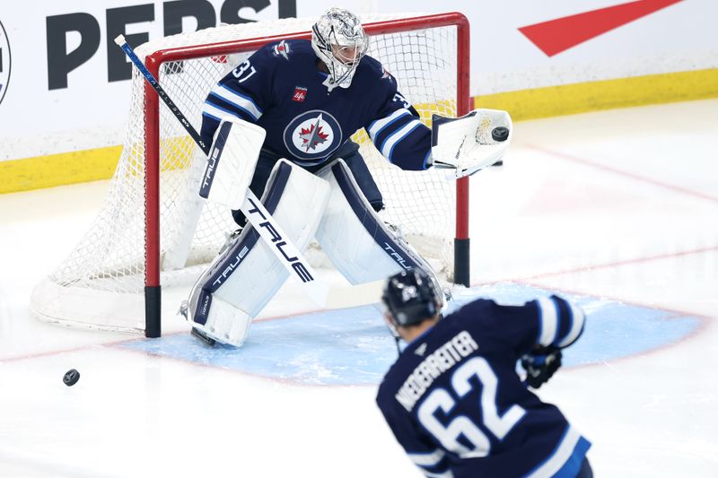May 9, 2025; Winnipeg, Manitoba, CAN; Winnipeg Jets goaltender Connor Hellebuyck (37) gloves a shot by right wing Nino Niederreiter (62) before a game against the Dallas Stars in game two of the second round of the 2025 Stanley Cup Playoffs at Canada Life Centre. Mandatory Credit: James Carey Lauder-Imagn Images
