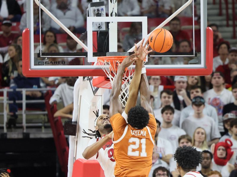 Feb 26, 2025; Fayetteville, Arkansas, USA; Arkansas Razorbacks forward Jonas Aidoo (9) blocks a shot attempt by Texas Longhorns forward Ze’Rik Onyema (21) during the first half at Bud Walton Arena. Mandatory Credit: Nelson Chenault-Imagn Images