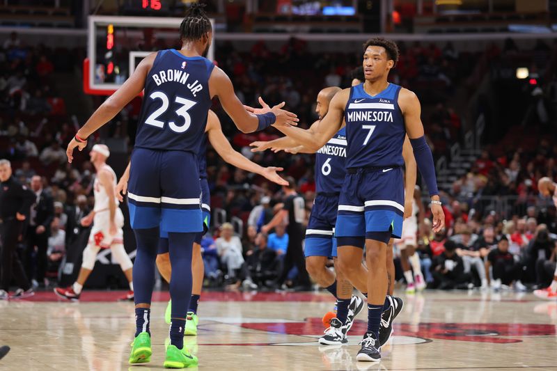 CHICAGO, ILLINOIS - OCTOBER 19: Troy Brown Jr. #23 and Wendell Moore Jr. #7 of the Minnesota Timberwolves high five against the Chicago Bulls during the second half of a preseason game at the United Center on October 19, 2023 in Chicago, Illinois. NOTE TO USER: User expressly acknowledges and agrees that, by downloading and or using this photograph, User is consenting to the terms and conditions of the Getty Images License Agreement.  (Photo by Michael Reaves/Getty Images)