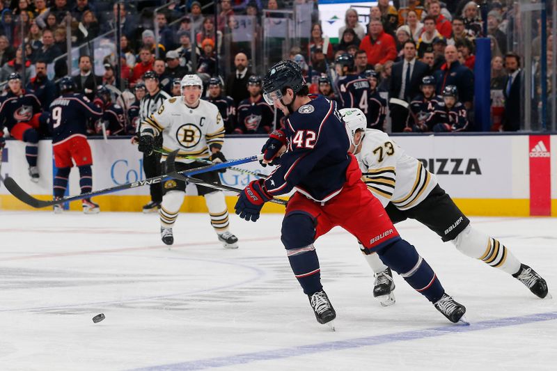 Jan 2, 2024; Columbus, Ohio, USA; Boston Bruins defenseman Charlie McAvoy (73) lifts the stick k of Columbus Blue Jackets center Alexander Texier (42) during the first period at Nationwide Arena. Mandatory Credit: Russell LaBounty-USA TODAY Sports