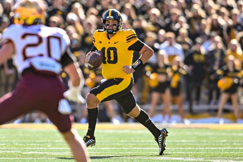 Oct 21, 2023; Iowa City, Iowa, USA; Iowa Hawkeyes quarterback Deacon Hill (10) runs with the ball during the first quarter against the Minnesota Golden Gophers at Kinnick Stadium. Mandatory Credit: Jeffrey Becker-USA TODAY Sports