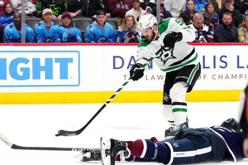 Apr 7, 2024; Denver, Colorado, USA; Dallas Stars center Tyler Seguin (91) shoots the puck over Colorado Avalanche defenseman Cale Makar (8) in the third period at Ball Arena. Mandatory Credit: Ron Chenoy-USA TODAY Sports