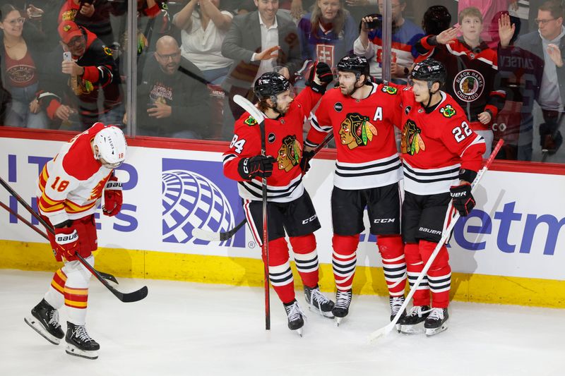 Mar 26, 2024; Chicago, Illinois, USA; Chicago Blackhawks center Jason Dickinson (16) celebrates with teammates after scoring against the Calgary Flames during the first period at United Center. Mandatory Credit: Kamil Krzaczynski-USA TODAY Sports