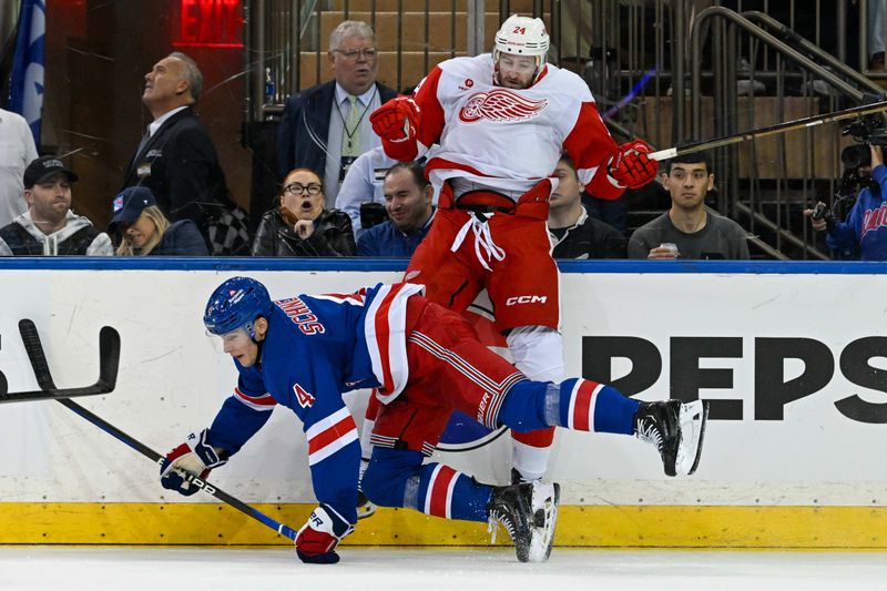 Oct 14, 2024; New York, New York, USA;  New York Rangers defenseman Braden Schneider (4) checks Detroit Red Wings left wing Austin Watson (24) during the first period at Madison Square Garden. Mandatory Credit: Dennis Schneidler-Imagn Images