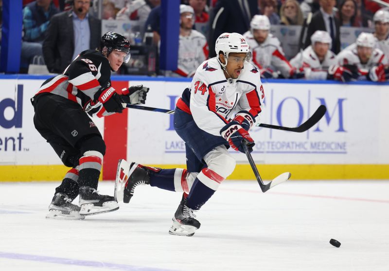 Mar 12, 2026; Buffalo, New York, USA;  Washington Capitals center Justin Sourdif (34) controls the puck as Buffalo Sabres defenseman Rasmus Dahlin (26) tries to defend during the second period at KeyBank Center. Mandatory Credit: Timothy T. Ludwig-Imagn Images