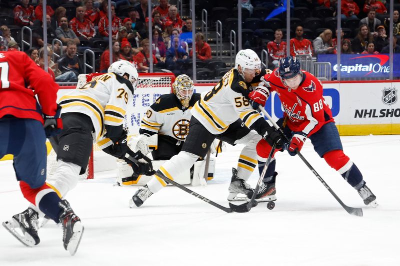 Oct 5, 2024; Washington, District of Columbia, USA; Washington Capitals left wing Andrew Mangiapane (88) and Boston Bruins defenseman Billy Sweezey (58) battle for the puck in  front of Bruins goaltender Brandon Bussi (30) in the first period at Capital One Arena. Mandatory Credit: Geoff Burke-Imagn Images