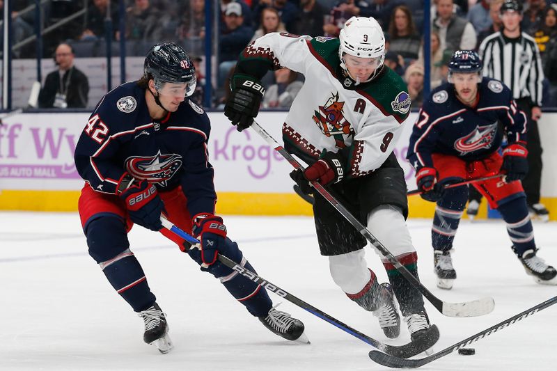 Nov 16, 2023; Columbus, Ohio, USA; Columbus Blue Jackets center Alexander Texier (42) sticks the puck away from Arizona Coyotes center Clayton Keller (9) during the first period at Nationwide Arena. Mandatory Credit: Russell LaBounty-USA TODAY Sports