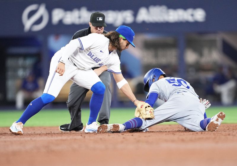 Apr 26, 2024; Toronto, Ontario, CAN; Los Angeles Dodgers shortstop Mookie Betts (50) is safe at second base ahead of the tag from Toronto Blue Jays shortstop Bo Bichette (11) during the third inning at Rogers Centre. Mandatory Credit: Nick Turchiaro-USA TODAY Sports