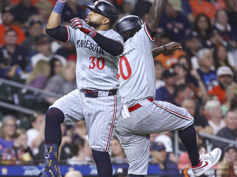 May 31, 2024; Houston, Texas, USA; Minnesota Twins first baseman Carlos Santana (30) celebrates with third base coach/outfield coach Tommy Watkins (40) after hitting a home run during the eighth inning against the Houston Astros at Minute Maid Park. Mandatory Credit: Troy Taormina-USA TODAY Sports