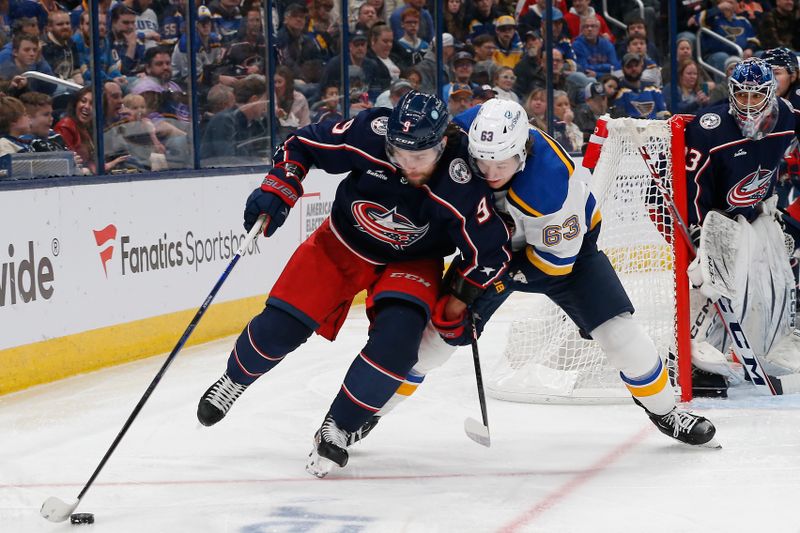 Dec 8, 2023; Columbus, Ohio, USA; Columbus Blue Jackets defenseman Ivan Provorov (9) and St. Louis Blues left wing Jake Neighbours (63) battle for the puck during the third period at Nationwide Arena. Mandatory Credit: Russell LaBounty-USA TODAY Sports