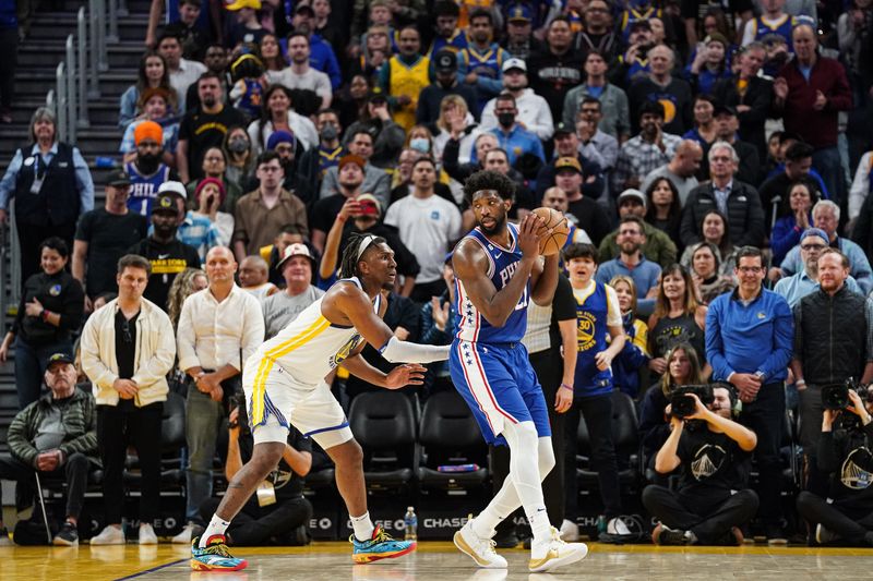 SAN FRANCISCO, CA - MARCH 24: Joel Embiid #21 of the Philadelphia 76ers dribbles with the ball in the fourth quarter against Kevon Looney #5 of the Golden State Warriors at Chase Center on March 24, 2023 in San Francisco, California. NOTE TO USER: User expressly acknowledges and agrees that, by downloading and/or using this photograph, User is consenting to the terms and conditions of the Getty Images License Agreement. (Photo by Kavin Mistry/Getty Images)