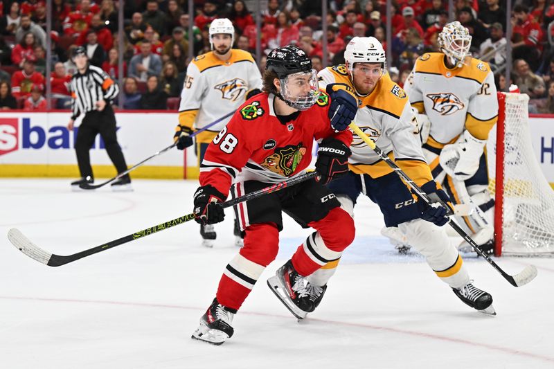 Apr 12, 2024; Chicago, Illinois, USA; Chicago Blackhawks forward Connor Bedard (98) and Nashville Predators defenseman Jeremy Lauzon (3) battle for position while chasing after a loose puck in the second period at United Center. Mandatory Credit: Jamie Sabau-USA TODAY Sports