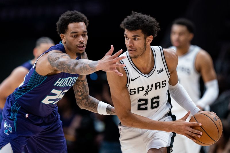 CHARLOTTE, NORTH CAROLINA - JANUARY 19: P.J. Washington #25 of the Charlotte Hornets guards Dominick Barlow #26 of the San Antonio Spurs in the fourth quarter during their game at Spectrum Center on January 19, 2024 in Charlotte, North Carolina. NOTE TO USER: User expressly acknowledges and agrees that, by downloading and or using this photograph, User is consenting to the terms and conditions of the Getty Images License Agreement. (Photo by Jacob Kupferman/Getty Images)