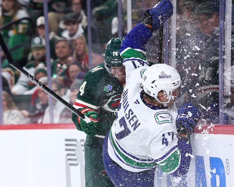 Dec 3, 2024; Saint Paul, Minnesota, USA; Minnesota Wild center Joel Eriksson Ek (14) checks Vancouver Canucks defenseman Noah Juulsen (47) during the third period at Xcel Energy Center. Mandatory Credit: Matt Krohn-Imagn Images