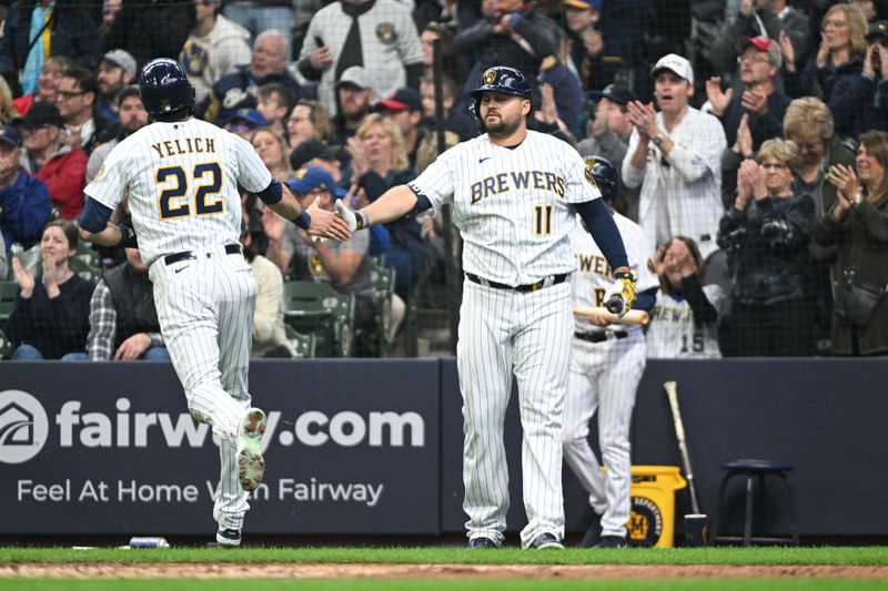 Apr 23, 2023; Milwaukee, Wisconsin, USA;  Milwaukee Brewers left fielder Christian Yelich (22) celebrates with Milwaukee Brewers first baseman Rowdy Tellez (11) after scoring a run against the Boston Red Sox in the fifth inning at American Family Field. Mandatory Credit: Michael McLoone-USA TODAY Sports