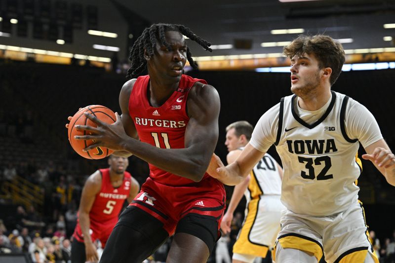 Jan 6, 2024; Iowa City, Iowa, USA; Rutgers Scarlet Knights center Clifford Omoruyi (11) controls the ball as Iowa Hawkeyes forward Owen Freeman (32) defends during the first half at Carver-Hawkeye Arena. Mandatory Credit: Jeffrey Becker-USA TODAY Sports