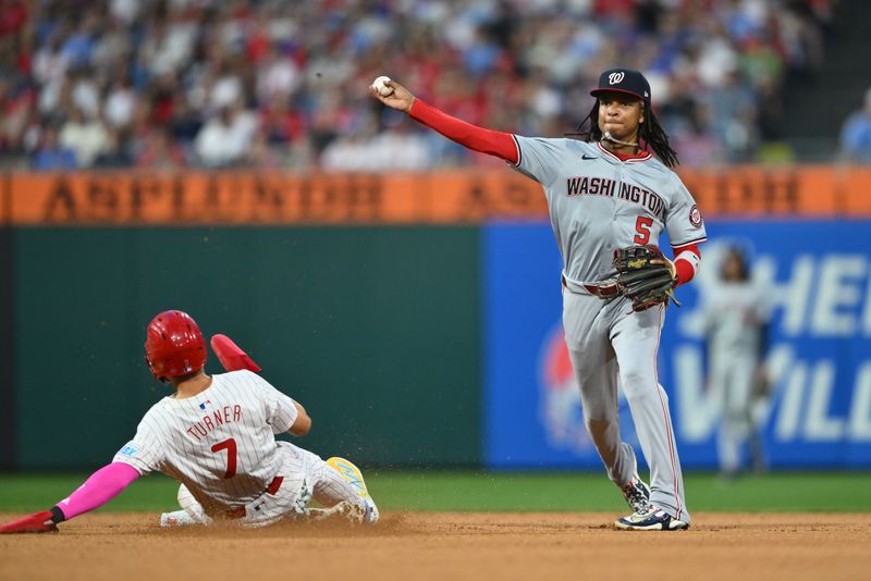 Aug 17, 2024; Philadelphia, Pennsylvania, USA; Washington Nationals infielder CJ Abrams (5) turns a double play over Philadelphia Phillies shortstop Trea Turner (7) in the fourth inning at Citizens Bank Park. Mandatory Credit: Kyle Ross-USA TODAY Sports