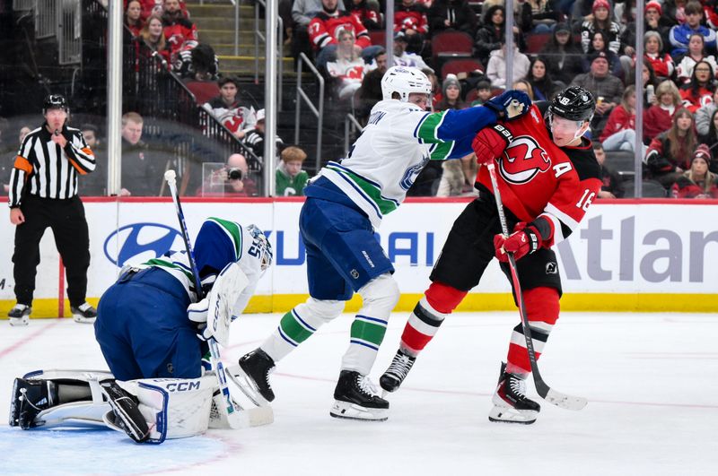 Dec 14, 2025; Newark, New Jersey, USA; Vancouver Canucks defenseman Elias Pettersson (25) checks New Jersey Devils left wing Ondrej Palat (18) during the second period at Prudential Center. Mandatory Credit: John Jones-Imagn Images