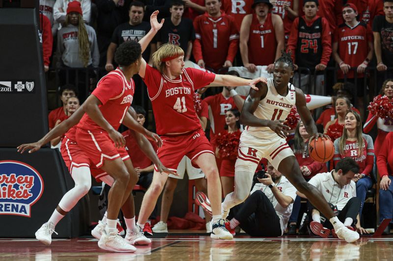 Nov 10, 2023; Piscataway, New Jersey, USA; Rutgers Scarlet Knights center Clifford Omoruyi (11) dribbles as Boston University Terriers forward Otto Landrum (41) defends during the first half at Jersey Mike's Arena. Mandatory Credit: Vincent Carchietta-USA TODAY Sports